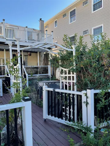 a view of a house with wooden deck and furniture