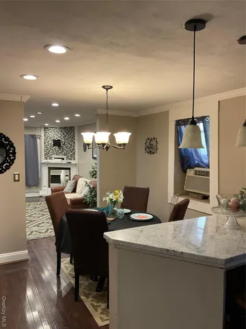 a dining room with furniture a chandelier and wooden floor