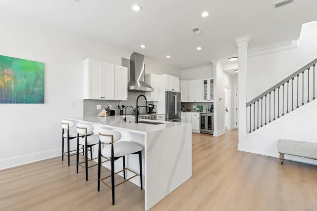 a kitchen with stainless steel appliances kitchen island granite countertop a table chairs sink and cabinets