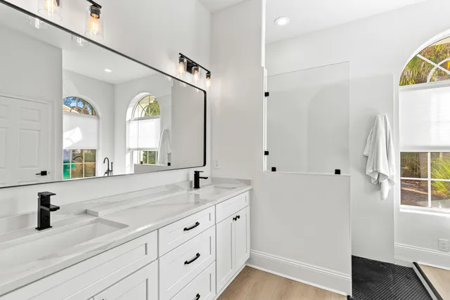 a bathroom with a double vanity sink and a window