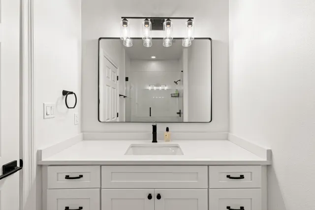 a bathroom with a sink vanity and mirror