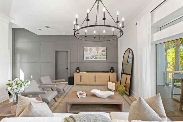 a living room with furniture a chandelier and a large window