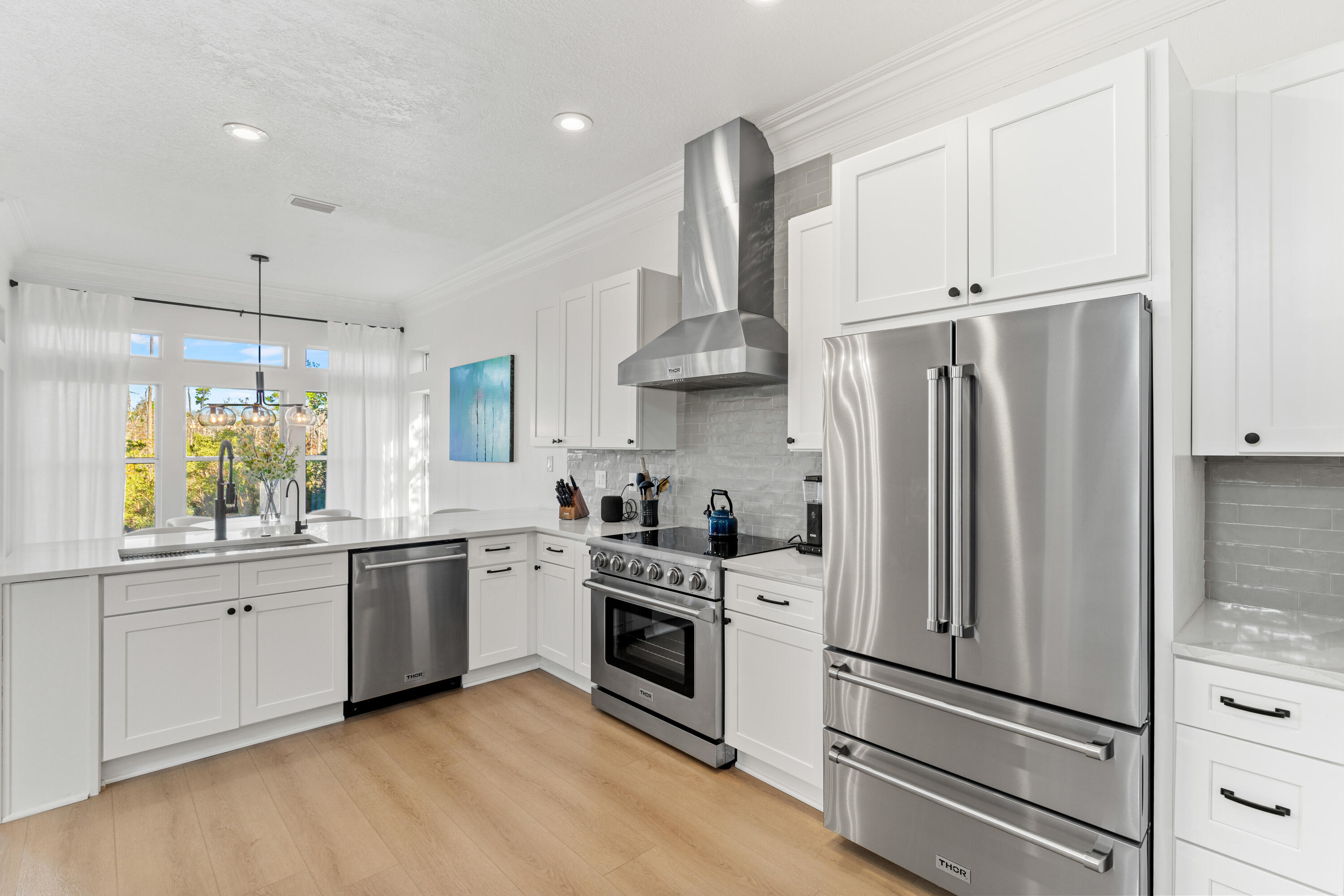 4591 Sailmaker Lane Destin, FL 32541 - Photo 10 of 41 a kitchen with stainless steel appliances a sink cabinets and a wooden floor
