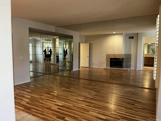 an empty room with wooden floor and fire place