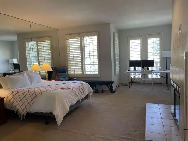 a spacious bedroom with a bed and wooden floor