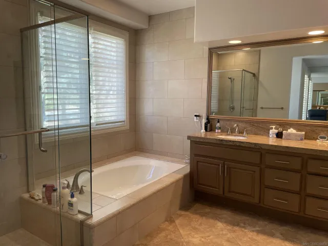 a bathroom with a tub sink and mirror