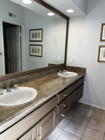 a bathroom with a granite countertop sink and a mirror