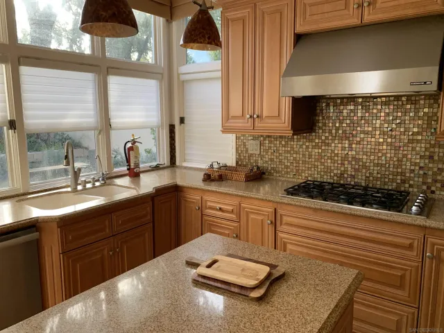 a kitchen with a sink a stove and cabinets