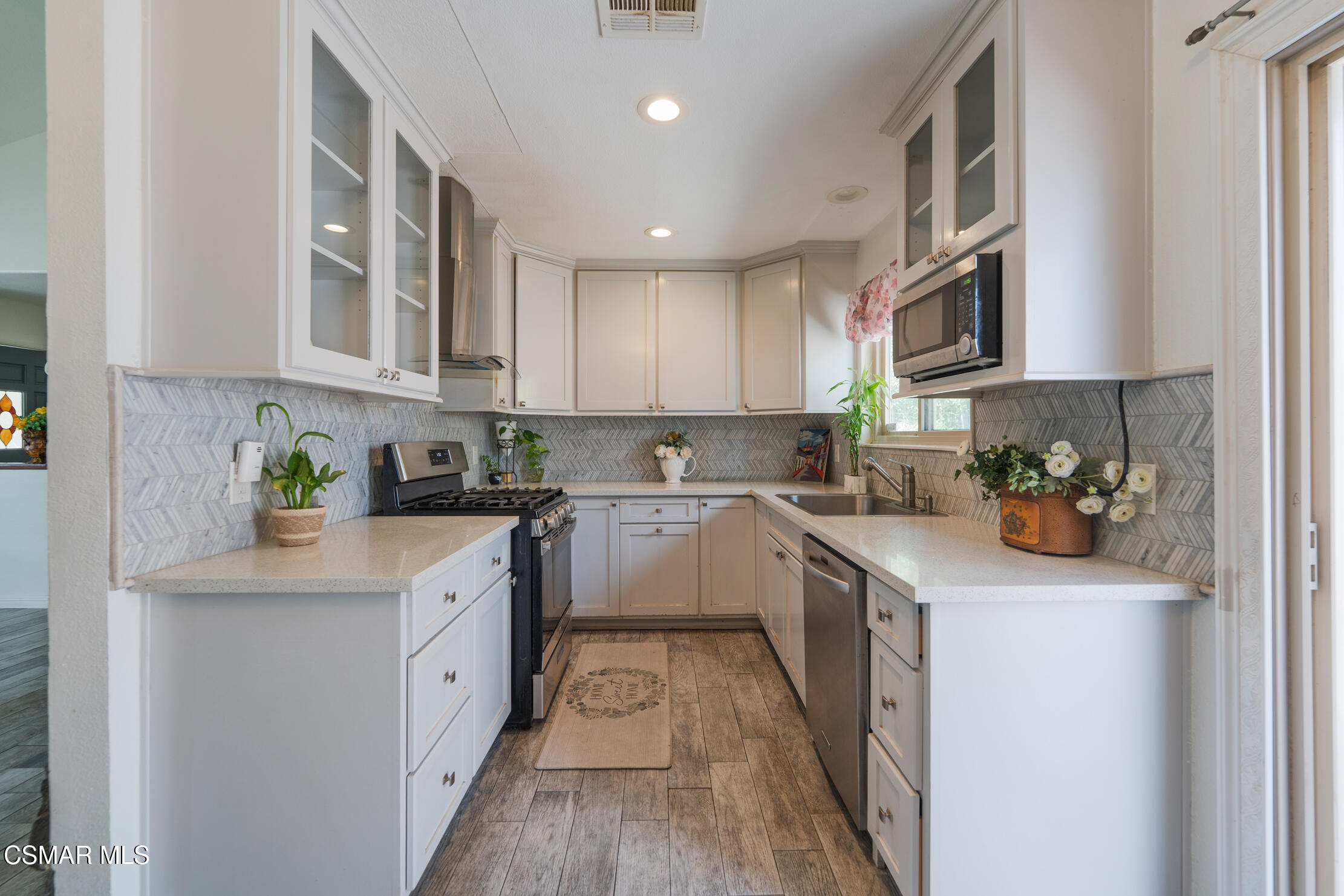 1917 Fitzgerald Road Simi Valley, CA 93065 - Photo 3 of 55 a kitchen with stainless steel appliances granite countertop a sink a stove top oven a refrigerator a sink and dishwasher with white cabinets