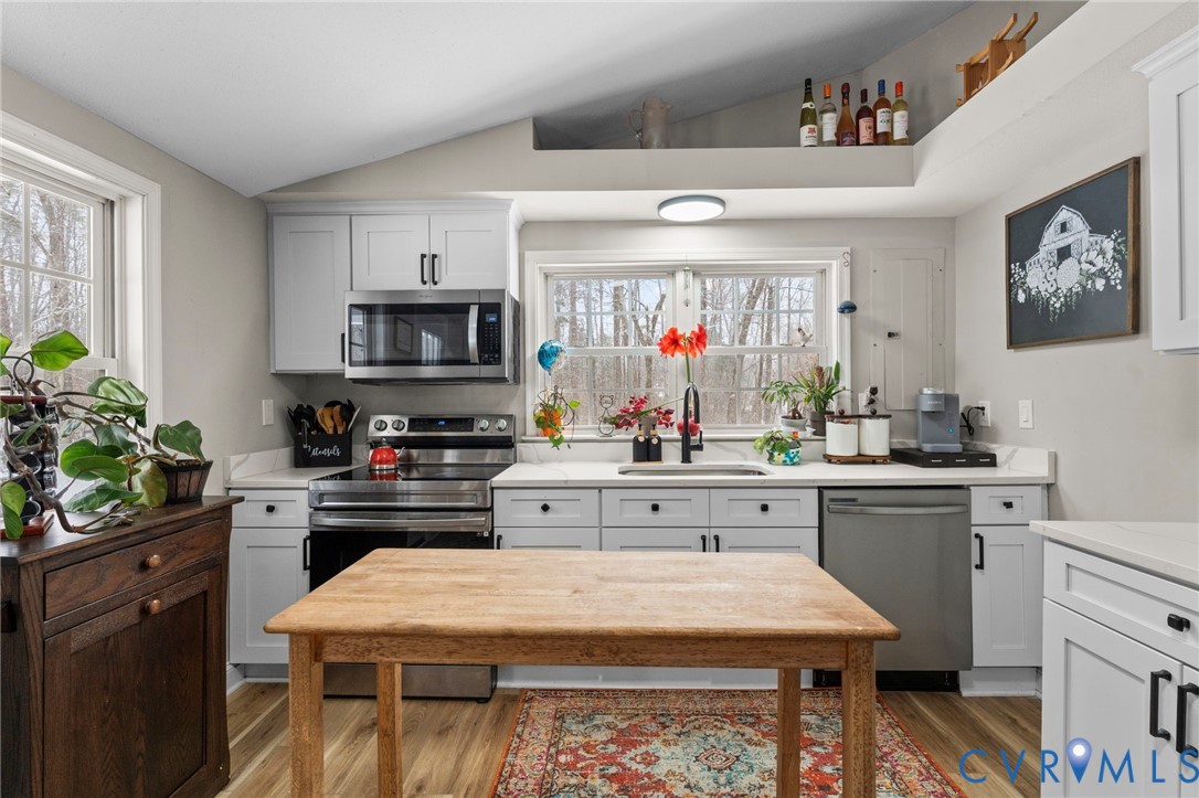 675 Goldmine Road Louisa, VA 23093 - Photo 16 of 29 a kitchen with a stove a sink dishwasher and white cabinets with wooden floor