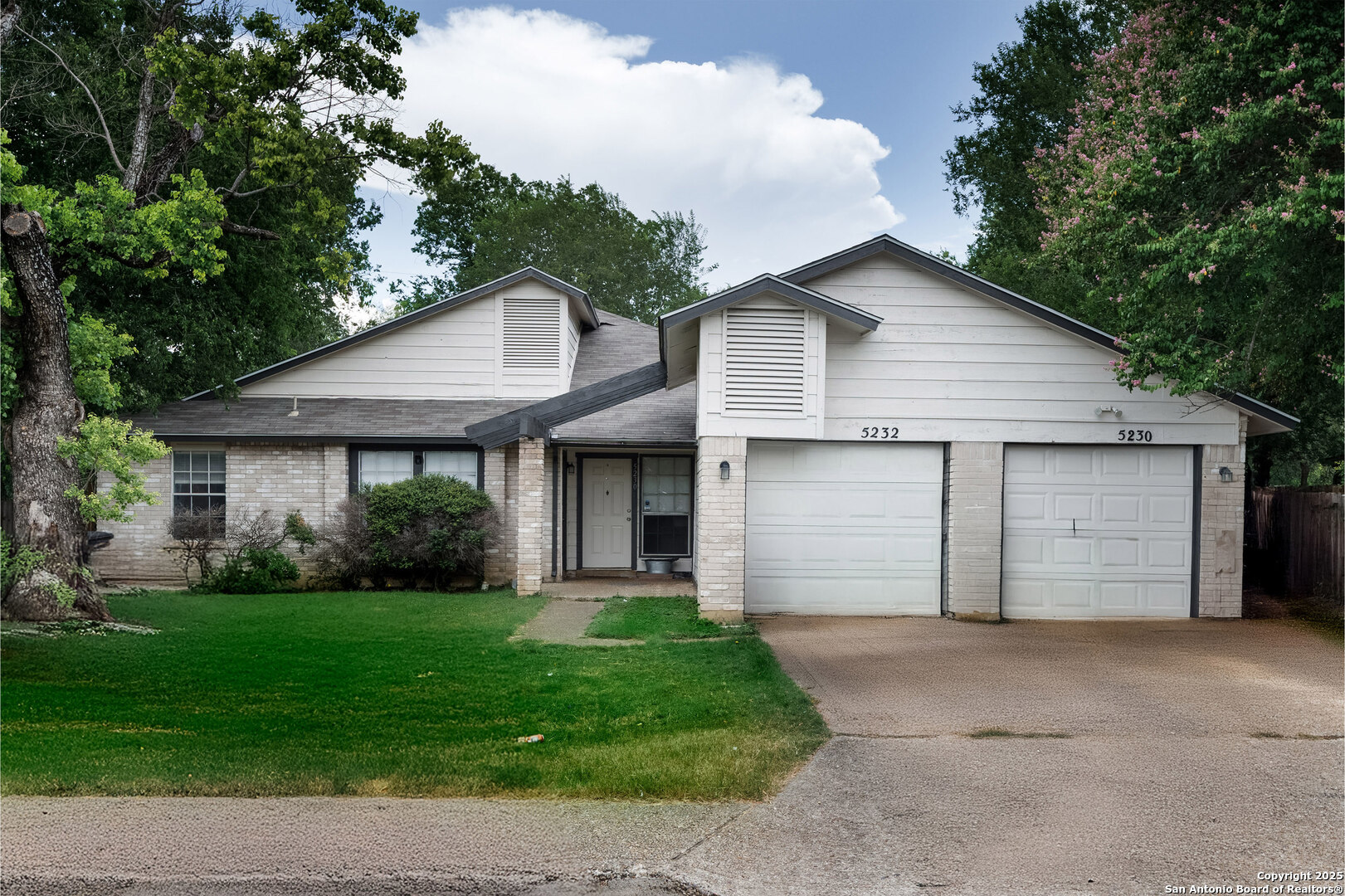 a front view of a house with a garden and yard