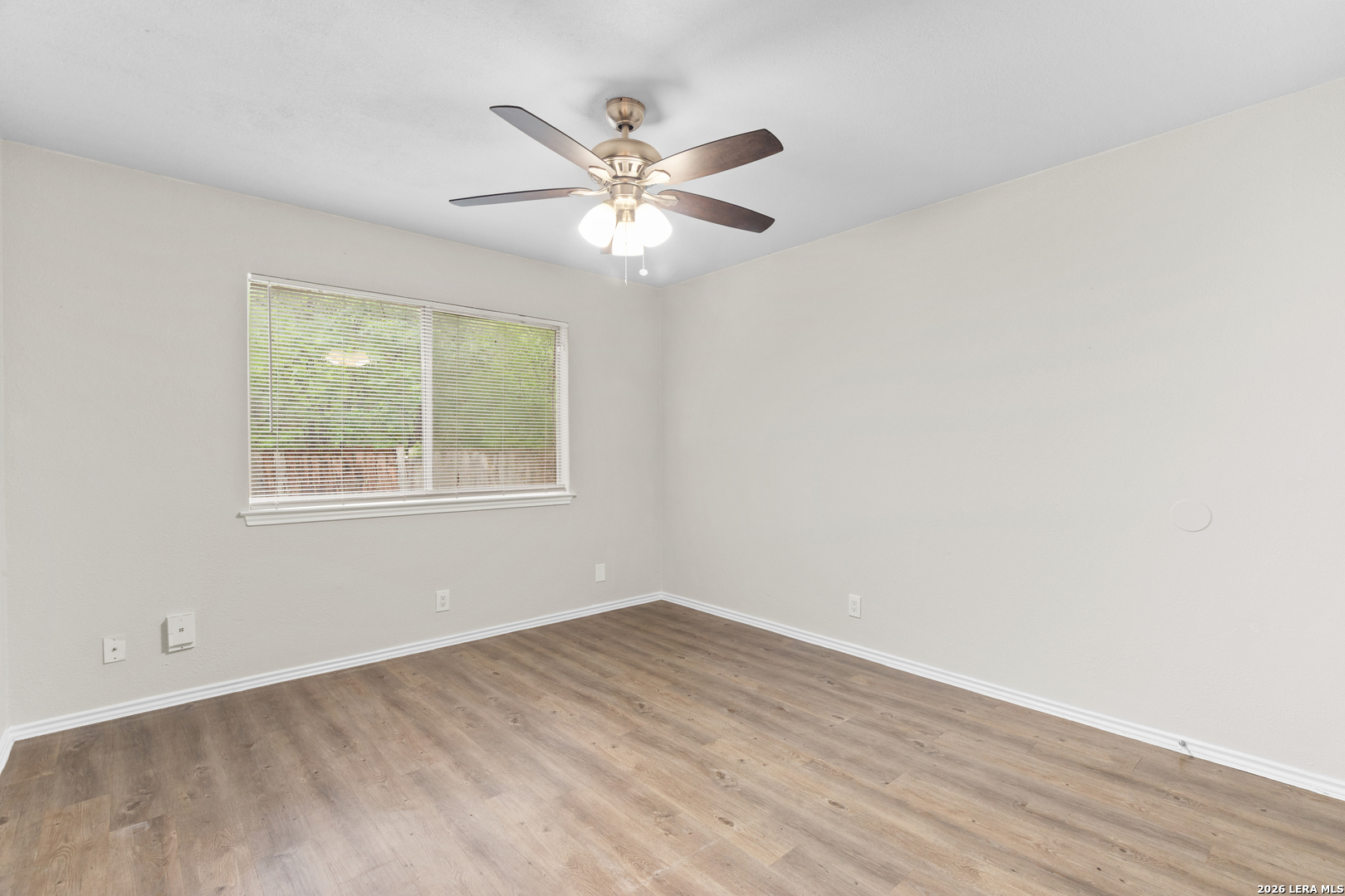 5230 Meadow Rise Street San Antonio, TX 78250 - Photo 21 of 30 a view of an empty room with wooden floor and a window