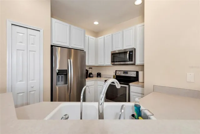 a kitchen with white cabinets and stainless steel appliances
