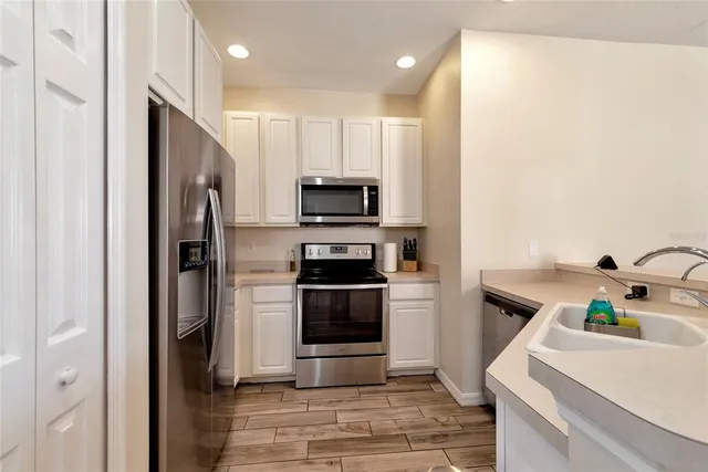 a kitchen with stainless steel appliances a refrigerator sink and microwave
