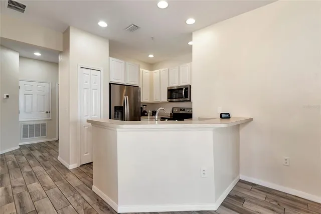 a kitchen with a refrigerator a microwave a stove cabinets and a sink
