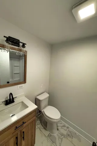 a bathroom with a toilet a sink and mirror