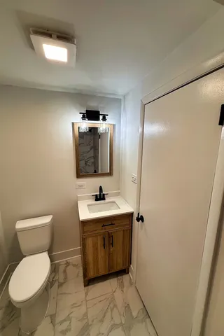 a bathroom with a toilet sink and mirror
