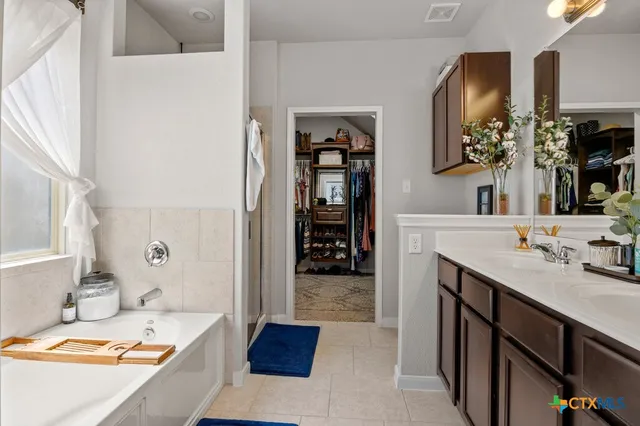 a bathroom with a tub sink and mirror