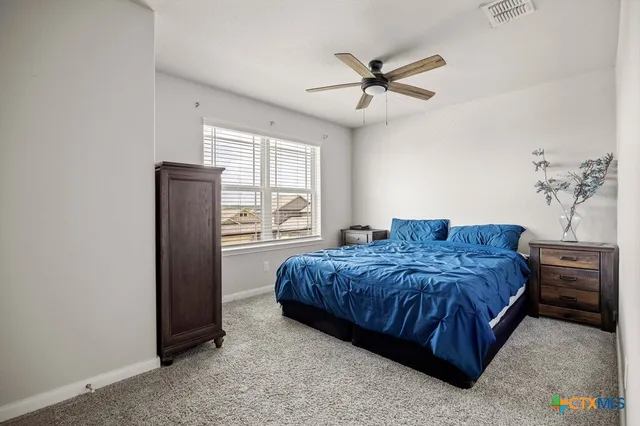 a spacious bedroom with a bed and a chandelier