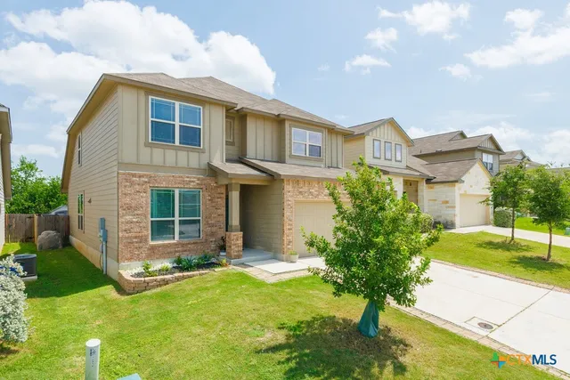 a front view of a house with a yard and trees