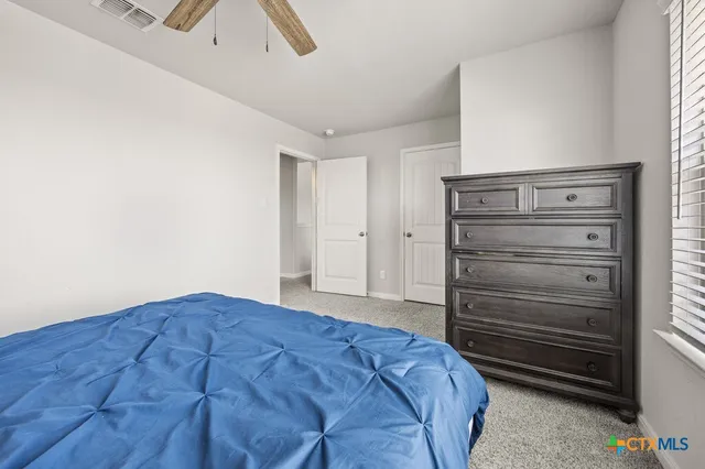 a bedroom with a bed and a ceiling fan
