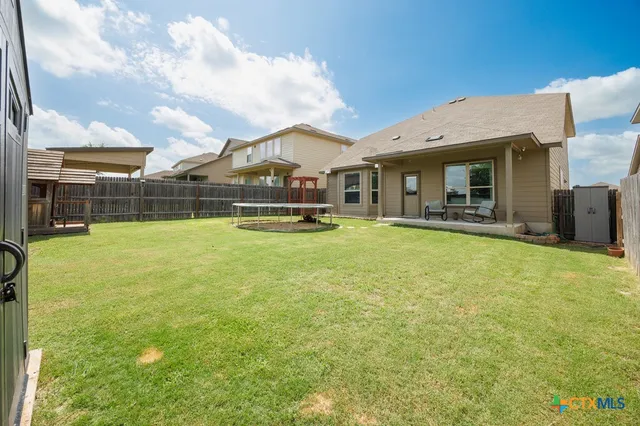a view of a house with a big yard and sitting area