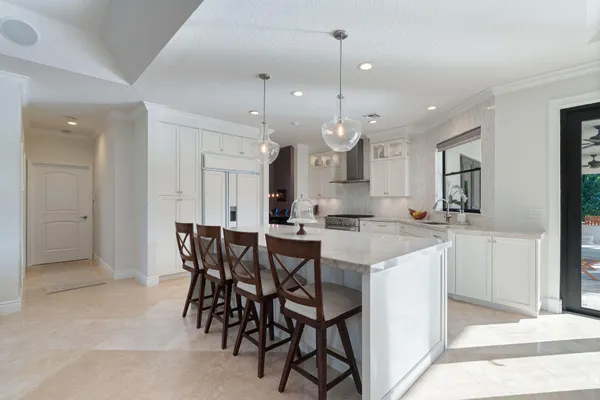 a kitchen with a dining table chairs and white cabinets