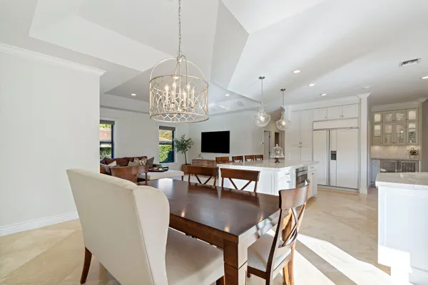a view of a dining room with furniture a chandelier and wooden floor