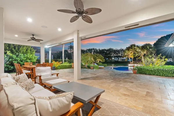a view of a patio with a table chairs and a floor to ceiling window