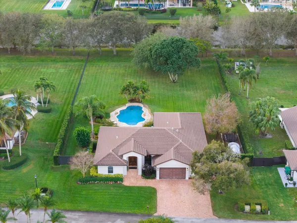 an aerial view of a house with a garden and lake view