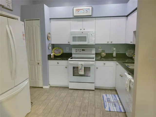 a kitchen with stainless steel appliances granite countertop a sink a stove and cabinets