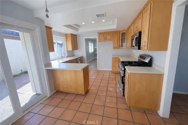 a kitchen with stainless steel appliances granite countertop a sink and a refrigerator