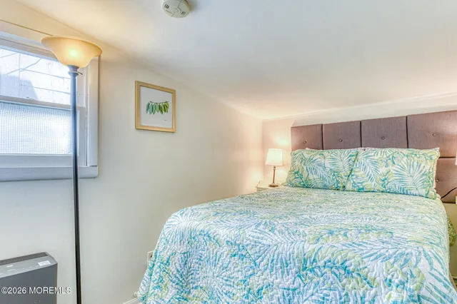 a large bed sitting in a bedroom next to a window