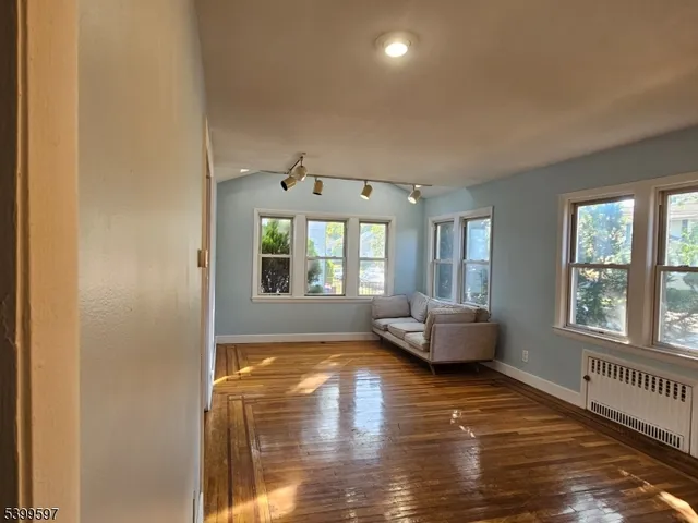a living room with furniture wooden floor and a window