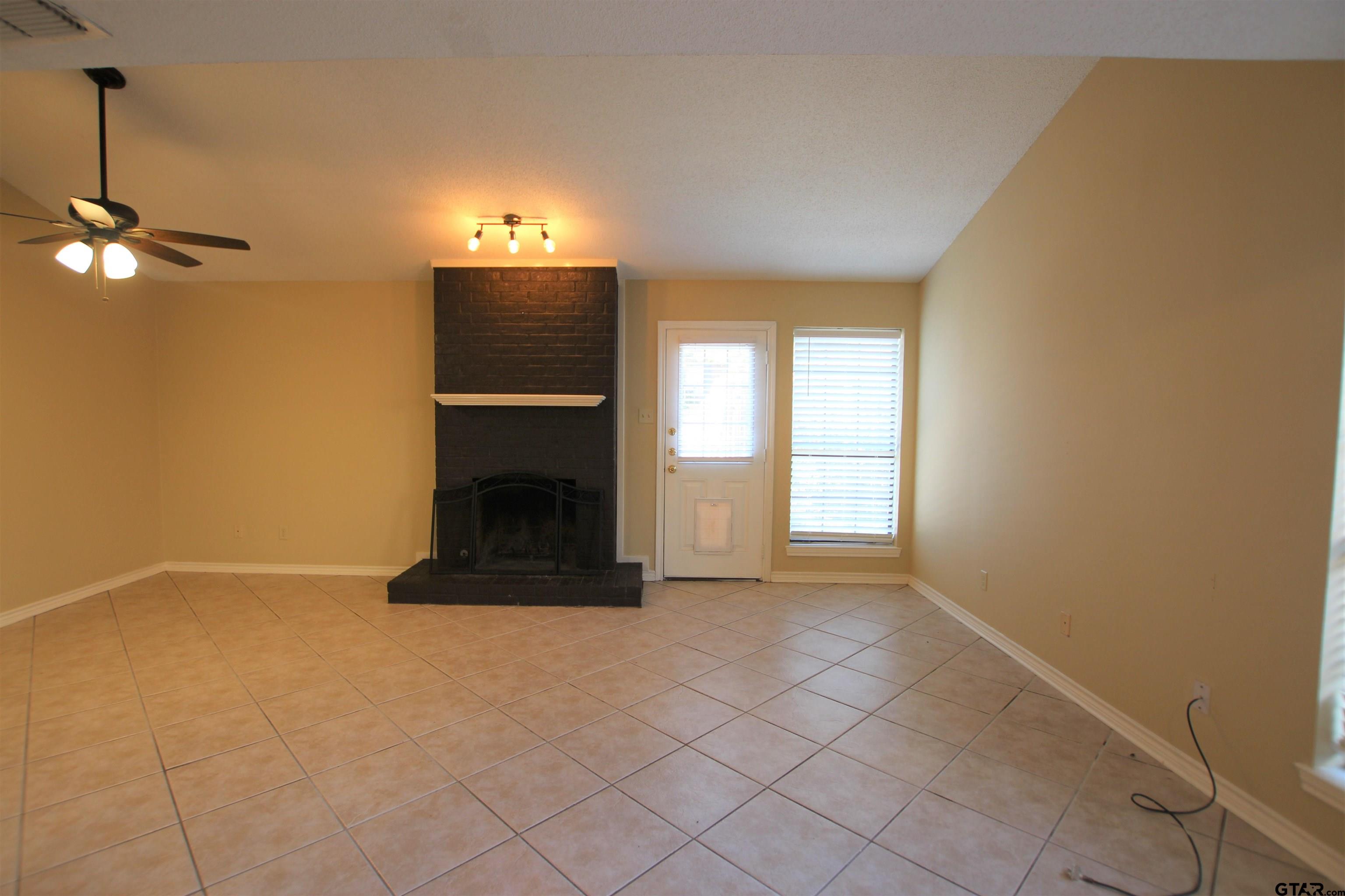 5875 Creekside Circle Tyler, TX 75703 - Photo 9 of 32 a view of an empty room with a fireplace and a window