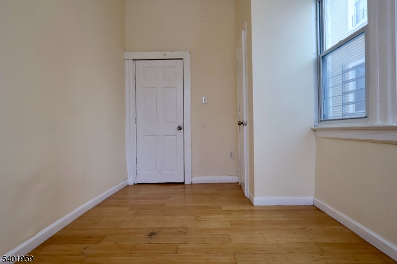 14 Wainwright Street, Unit 1 Newark, NJ 07112 - Photo 14 of 17 a view of an empty room with wooden floor and a window