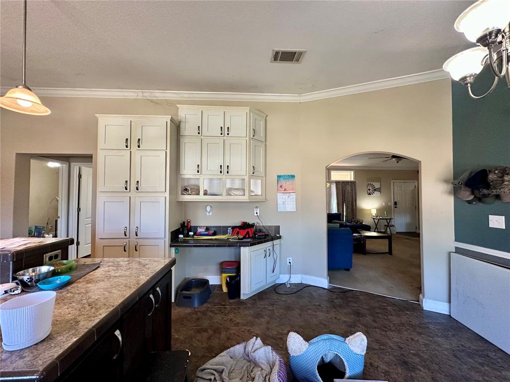 237 Southwest Baron Glen Fort White, FL 32038 - Photo 20 of 30 a kitchen with a stove a refrigerator and a dining table with wooden floor