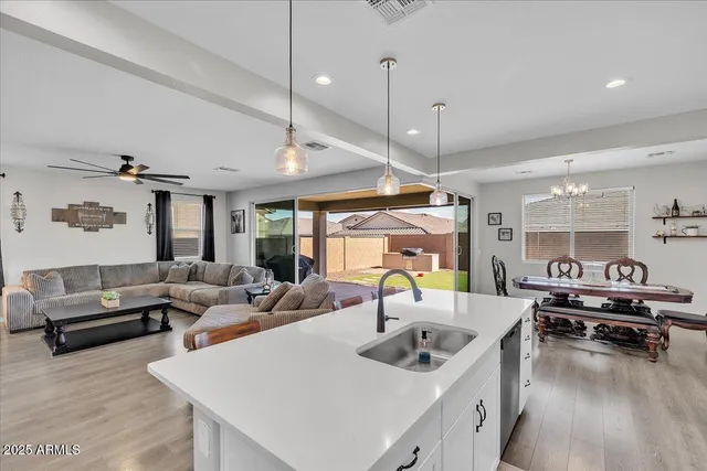 a living room with furniture kitchen view and a wooden floor