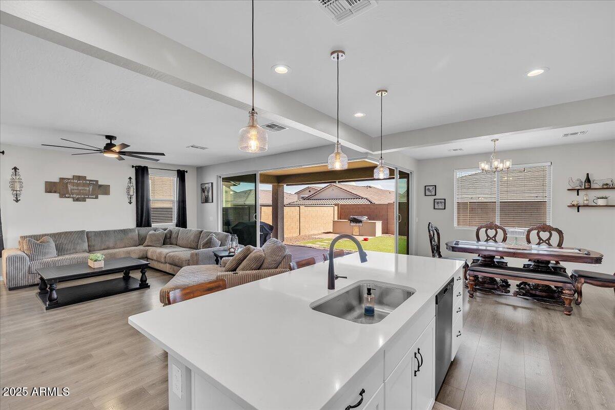 17593 West Red Fox Road Surprise, AZ 85387 - Photo 15 of 55 a kitchen with a stove a counter space a sink and living room view