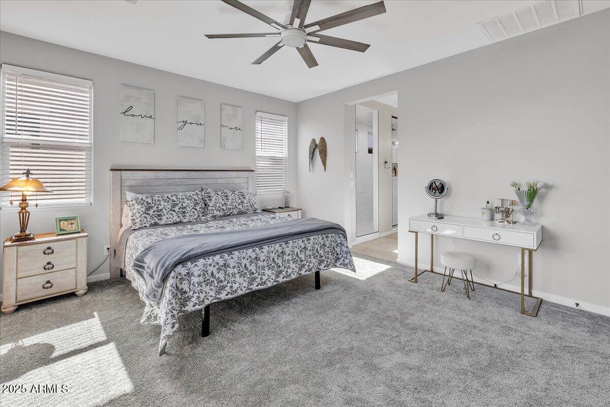 17593 West Red Fox Road Surprise, AZ 85387 - Photo 20 of 55 a bedroom with a bed and a chandelier