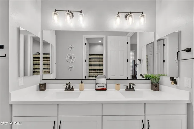 a bathroom with double sink and a mirror