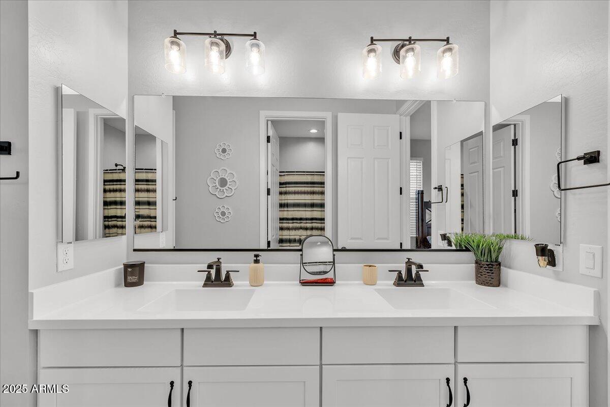 17593 West Red Fox Road Surprise, AZ 85387 - Photo 23 of 55 a bathroom with double vanity sinks and a mirror