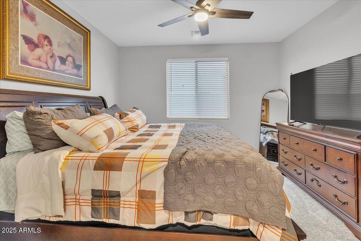 17593 West Red Fox Road Surprise, AZ 85387 - Photo 26 of 55 a bedroom with a bed and a flat screen tv