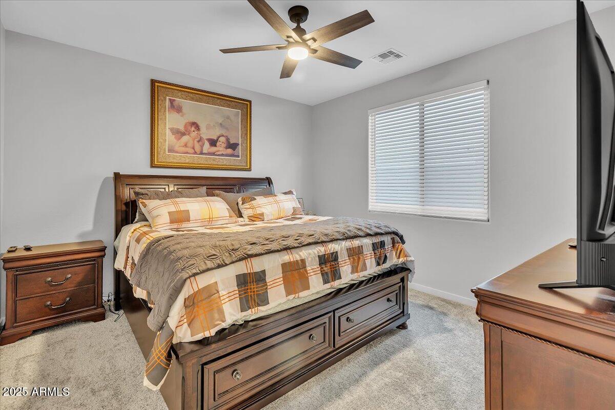 17593 West Red Fox Road Surprise, AZ 85387 - Photo 27 of 55 a bedroom with a bed and a chandelier