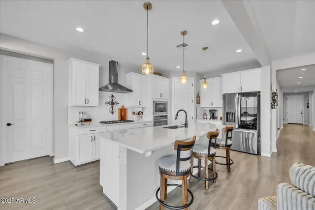 a kitchen with refrigerator a sink and chairs
