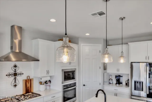 a large kitchen with stainless steel appliances kitchen island granite countertop a stove a sink a refrigerator and a dining table with wooden floor