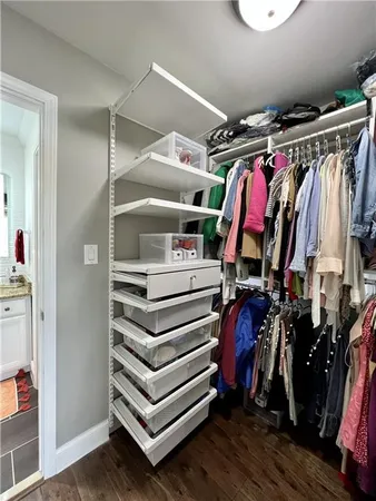 a view of walk in closet with clothes and shoes