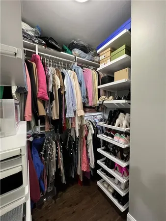 a view of walk in closet with clothes and shoes