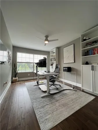 a living room with furniture a flat screen tv and a wooden floor