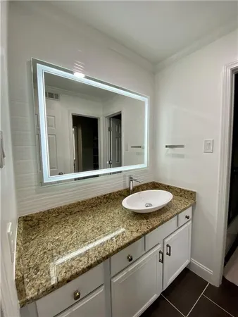 a bathroom with a granite countertop sink and a mirror